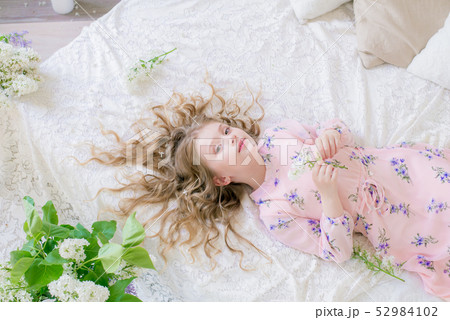 little girl with blond hair with lilac flowers 52984102