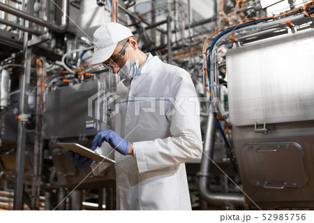 man in a white robe and a cap make an inspection of the production line man in a white robe and a cap make an inspection of the production line 52985756