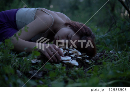 Young Beautiful Attractive woman in Purple Skirt Lay on a stump with white mushrooms at Mysterious 52988903