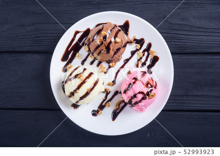 Ice cream with walnuts and chocolate topping 52993923