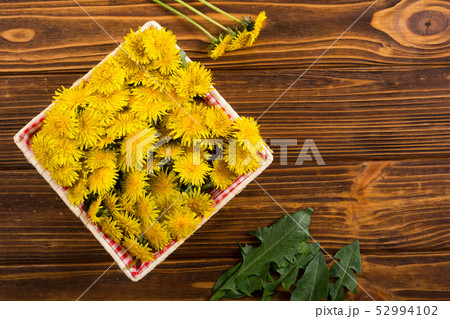Basket with yellow dandelion flower 52994102