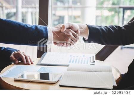 Finishing up a meeting, handshake of two happy Finishing up a meeting, handshake of two happy 52995457