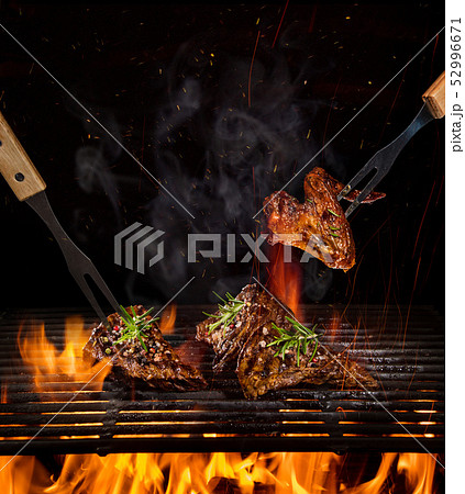 Beef steaks on the grill with flames 52996671