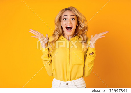 Excited Millennial Woman Screaming Over Yellow Background 52997341