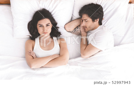 Young couple in bed having problems and crisis Young couple in bed having problems and crisis 52997943