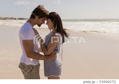 Romantic happy young couple head to head on beach 53000272