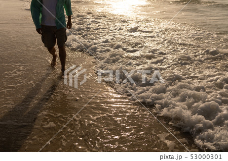 Senior man walking on the beach 53000301