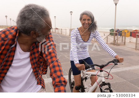 Senior couple with bicycle looking each other on promenade Senior couple with bicycle looking each other on promenade 53000334