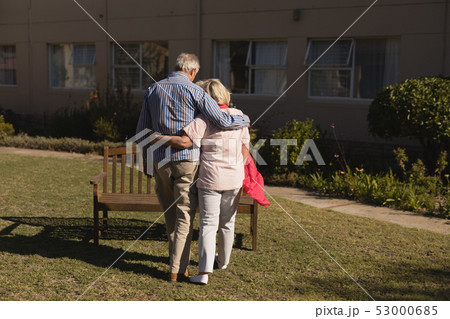 Senior couple standing with arm around in the park Senior couple standing with arm around in the park 53000685