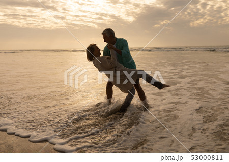 Senior couple dancing together on the beach 53000811
