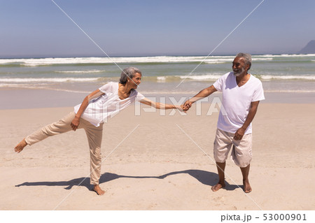 Senior couple holding hands on beach Senior couple holding hands on beach 53000901