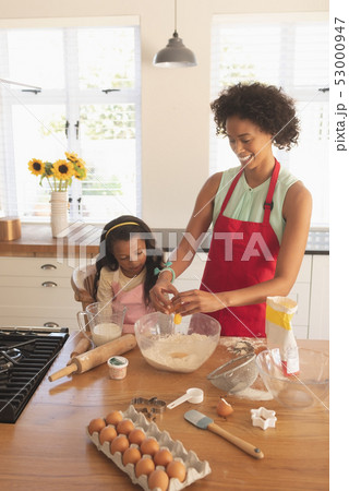African American mother and daughter baking cookies in kitchen African American mother and daughter baking cookies in kitchen 53000947