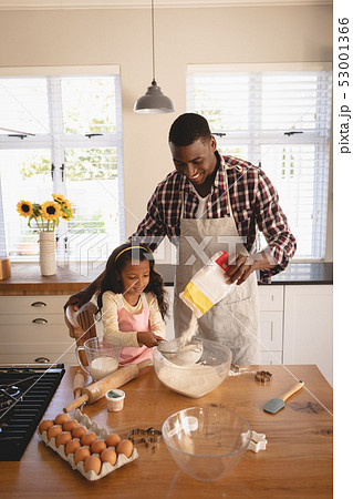 African American father and daughter baking cookies in kitchen 53001366