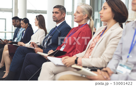 Side view of business people attending a business seminar 53001422