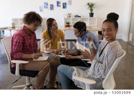Business colleagues interacting with each other in office Business colleagues interacting with each other in office 53001699