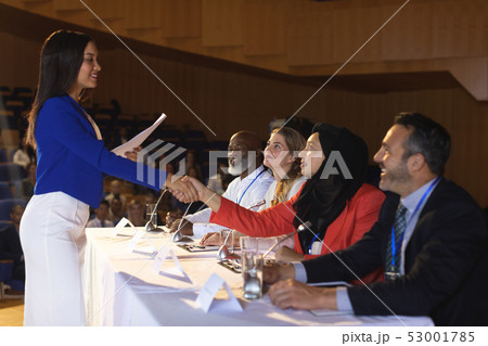 Business woman shaking hand to the business colleague in the auditorium Business woman shaking hand to the business colleague in the auditorium 53001785