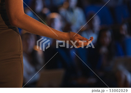 Businesswoman giving presentation in front of audience in auditorium 53002029