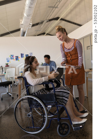 Disabled female executive discussing over digital tablet Disabled female executive discussing over digital tablet 53002102