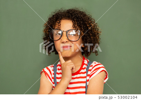 Schoolgirl standing against green board in a classroom at school Schoolgirl standing against green board in a classroom at school 53002104
