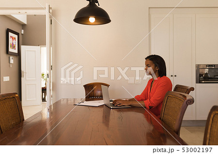 Woman using laptop at home 53002197