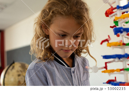Schoolgirl learning on science model in classroom 53002235