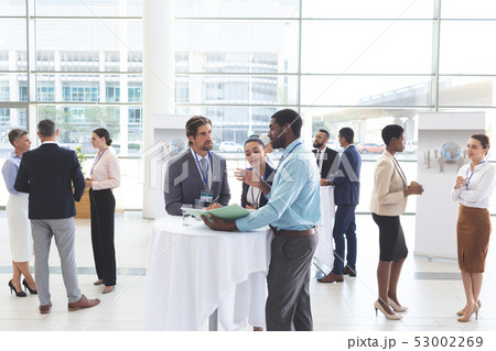 Business people discussing over documents at table during a seminar Business people discussing over documents at table during a seminar 53002269