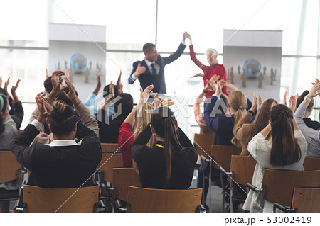 Business people applauding and celebrating in a business seminar 53002419