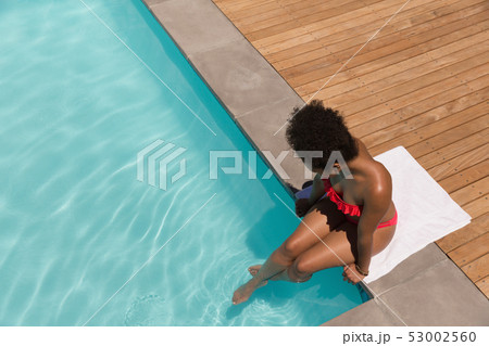 Woman relaxing in a swimming pool on a sunny day 53002560