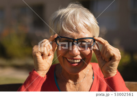 Senior woman in spectacle smiling in the park 53002561