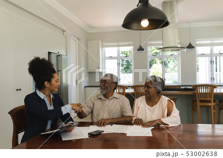 Female real estate agent shaking hands with senior man 53002638