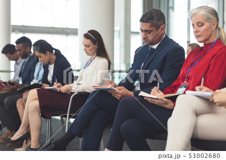 Business people writing on notepad in business seminar 53002680