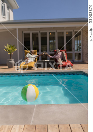 Senior couple toasting glasses of cocktail in the backyard of home 53002876