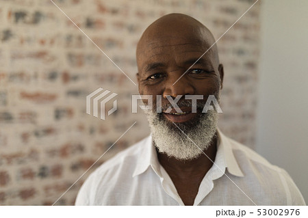 Black senior man smiling and standing at home 53002976