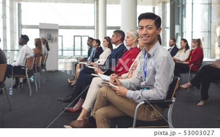 Happy businessman looking at camera in a seminar 53003027