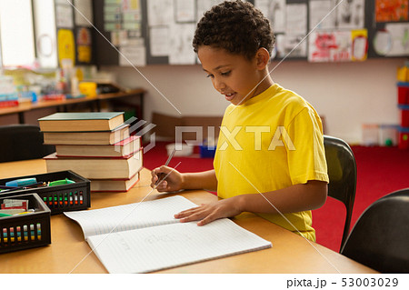 Schoolboy studying at desk in a classroom 53003029