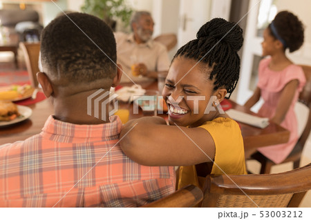 Multi-generation family having fun on dining table Multi-generation family having fun on dining table 53003212