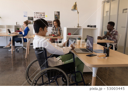 Disabled male executive using digital tablet at desk Disabled male executive using digital tablet at desk 53003445