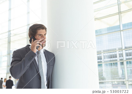 Businessman talking on mobile phone in lobby office Businessman talking on mobile phone in lobby office 53003722