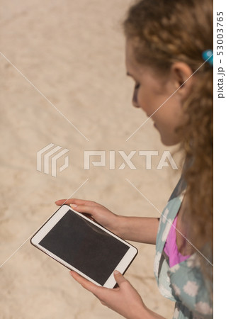 Young Caucasian woman using digital tablet at beach 53003765
