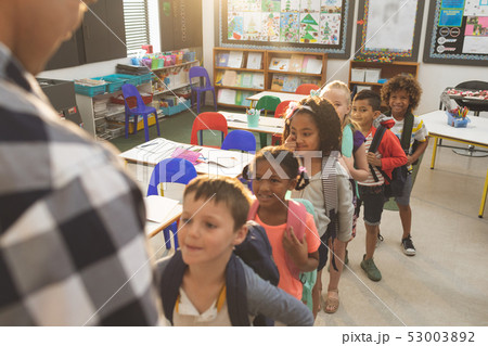 School kids standing and forming a queue in classroom at school 53003892