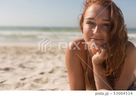 Young Caucasian woman in bikini lying on the sand and looking at camera on the beach 53004514