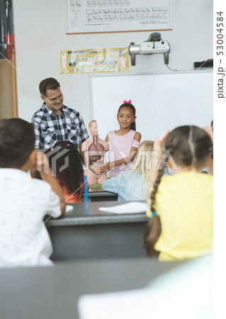 Schoolgirl explaining to his classmates the functioning of body humant thanks to a dummy skeleton Schoolgirl explaining to his classmates the functioning of body humant thanks to a dummy skeleton 53004584