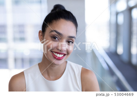 Pretty mixed-race businesswoman looking at camera in modern office 53004669