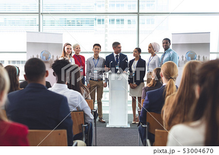 Businessman standing at podium with colleagues and speaks in a business seminar 53004670