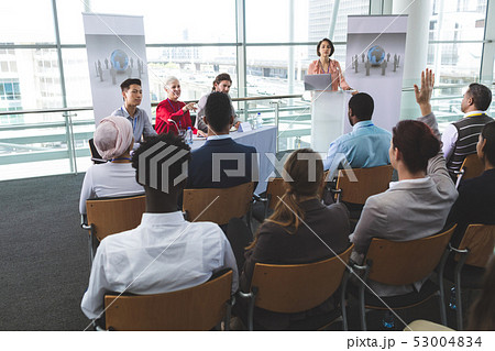 Businesswoman raising hand in a business seminar 53004834