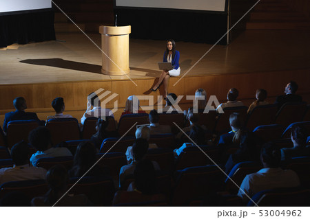 Businesswoman sitting at the side of the stage and having laptop in her hand  53004962