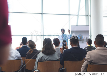 Businessman clicking photo with mobile phone in a business seminar Businessman clicking photo with mobile phone in a business seminar 53005013
