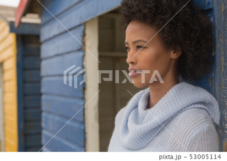 Young African American woman leaning against beach hut Young African American woman leaning against beach hut 53005114