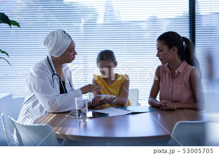 Matured female doctor examining girl hand in clinic 53005705