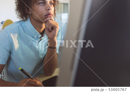 Male graphic designer with hand on chin working 53005767